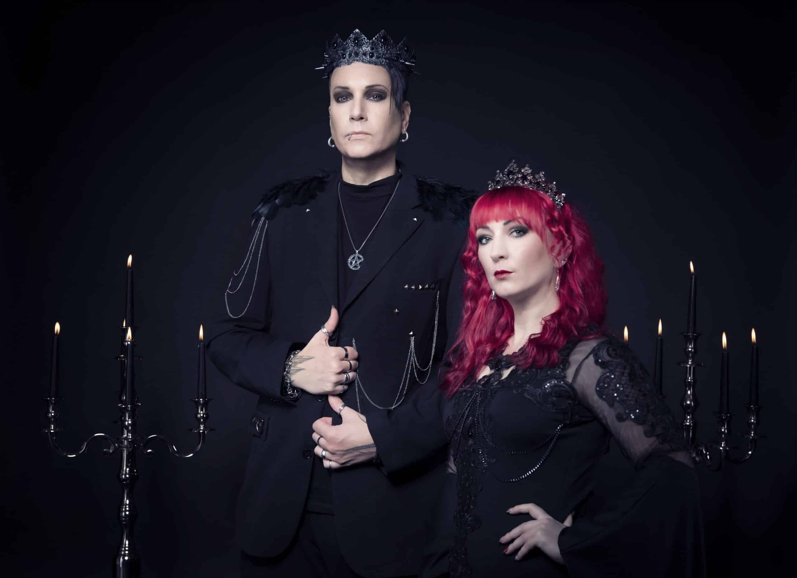 A man and woman posing in front of a black background with candles for the Blutengel music video "Un:Sterblich - Our Souls Will Never Die".