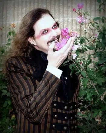 A man in a suit with a flower in his mouth, featured on the cover of Elektrikill's Monsters album.