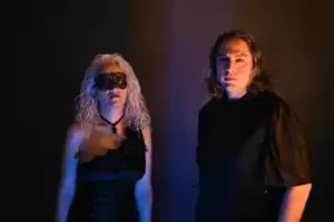 A man and woman standing next to each other in a dark room.