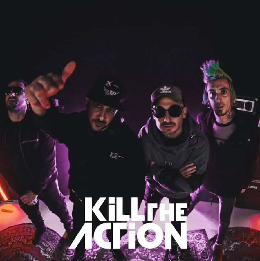 Four men in casual attire, one sporting colorful hair, stand under dim lighting. The text "Kill the Action" is boldly displayed at the bottom, hinting at an exclusive Kill The Action interview.