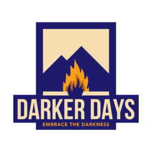 Logo with stylised mountains, a campfire, and bold text "Darker Days" above the phrase "Embrace the Darkness" on a navy and beige background.